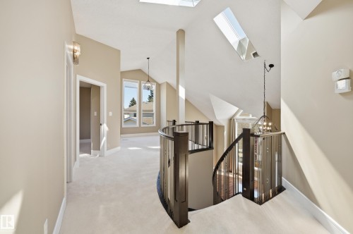 Curved staircase with dark wood newel posts and metal spindles - 394 Walker Road, Edmonton, AB - Indoor Photo Showing Other Room
