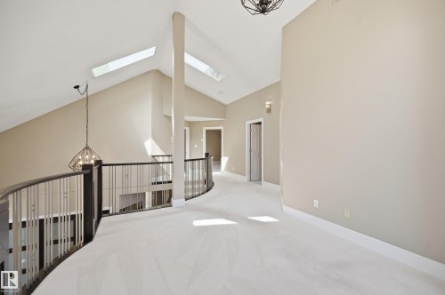 Spacious upper landing with vaulted ceilings, skylights, and light-toned carpeting - 394 Walker Road, Edmonton, AB - Indoor Photo Showing Other Room