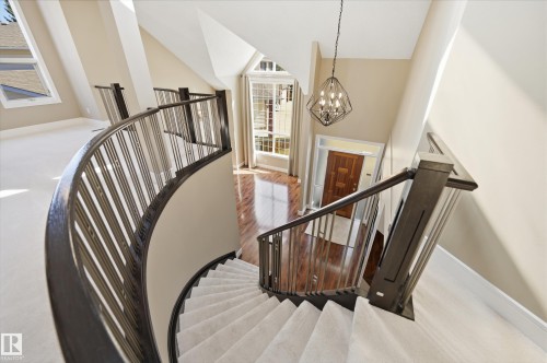 Curved staircase with carpeted treads and dark wood-finish railings - 394 Walker Road, Edmonton, AB - Indoor Photo Showing Other Room