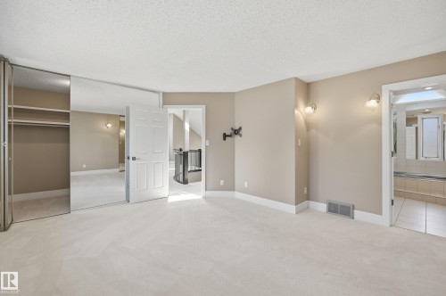 Spacious room featuring neutral carpeting and wall sconces - 394 Walker Road, Edmonton, AB - Indoor
