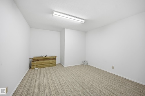 Spacious room featuring light-colored striped carpeting, white walls, and a textured ceiling - 394 Walker Road, Edmonton, AB - Indoor Photo Showing Other Room