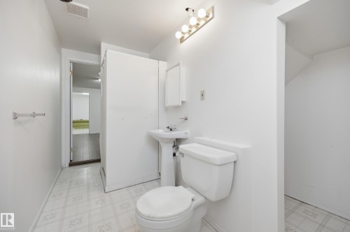Bathroom featuring a pedestal sink, white toilet, and patterned tile flooring - 394 Walker Road, Edmonton, AB - Indoor Photo Showing Bathroom
