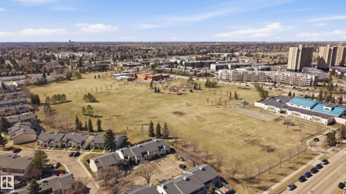Expansive open green space bordered by residential structures and a commercial building - 394 Walker Road, Edmonton, AB - Outdoor With View