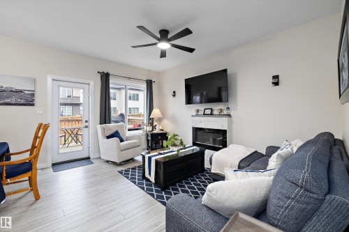 Bright living area featuring light wood-finish flooring and a ceiling fan - 82 Wingate Way, Fort Saskatchewan, AB - Indoor Photo Showing Living Room With Fireplace