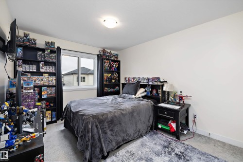 Bedroom featuring neutral wall paint, light gray carpeting, and a window with white trim - 82 Wingate Way, Fort Saskatchewan, AB - Indoor Photo Showing Bedroom
