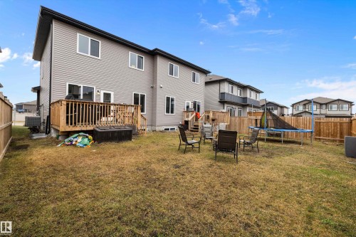 Spacious backyard featuring a wooden deck with railing, sliding glass door access, and privacy fencing - 82 Wingate Way, Fort Saskatchewan, AB - Outdoor With Backyard With Exterior