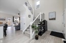 Two-story entryway featuring a carpeted staircase with white risers and black metal balusters - 82 Wingate Way, Fort Saskatchewan, AB  - Indoor Photo Showing Other Room 