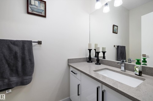 Full-width vanity mirror reflecting overhead lighting - 82 Wingate Way, Fort Saskatchewan, AB - Indoor Photo Showing Bathroom