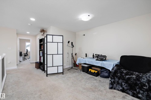 Carpeted loft area featuring recessed lighting, a ceiling-mounted light fixture, white walls, and white trim - 84 Wingate Way, Fort Saskatchewan, AB 