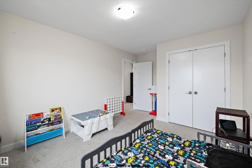 Carpeted room featuring light-colored walls and a semi-flush mount ceiling light - 84 Wingate Way, Fort Saskatchewan, AB 