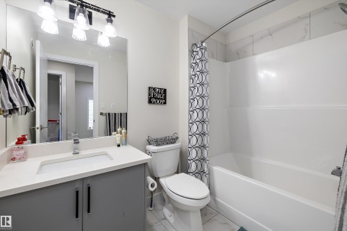Bathroom featuring a white integrated sink, light countertop, and gray base cabinetry - 84 Wingate Way, Fort Saskatchewan, AB 