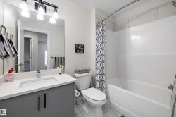 Bathroom featuring a white integrated sink, light countertop, and gray base cabinetry - 