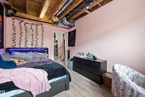Room featuring wood-finish flooring and an exposed ceiling with visible joists and ductwork - 84 Wingate Way, Fort Saskatchewan, AB 