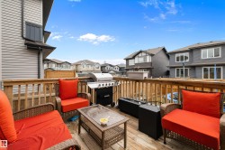 Spacious wooden deck featuring a slatted railing, a built-in outdoor speaker, and ample room for patio furnishings - 