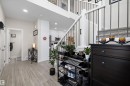Entryway featuring wood-finish flooring, white trim, recessed lighting, and a staircase with white risers and dark metal balusters - 84 Wingate Way, Fort Saskatchewan, AB 