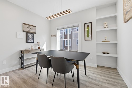 Bright interior space featuring a large window, recessed shelving, and wood-finish flooring - 61 230 Edgemont Road, Edmonton, AB - Indoor