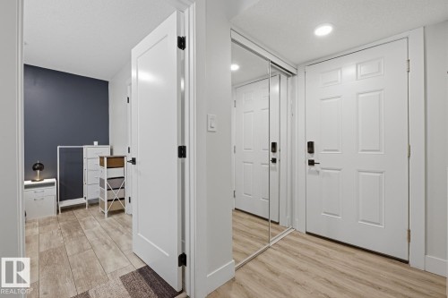 Entryway featuring wood-finish flooring, recessed lighting, and a mirrored closet - 61 230 Edgemont Road, Edmonton, AB - Indoor Photo Showing Other Room