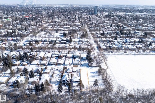 Aerial view showcasing the property within a snow-covered urban neighborhood, featuring residential homes with snow-dusted roofs and evergreen trees - 9209 96 Street Nw, Edmonton, AB 
