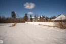 The property features an expansive lot with a white fence along one boundary - 9209 96 Street Nw, Edmonton, AB 