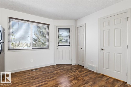Hardwood-finish flooring complementing white walls and trim - 18 6032 38 Avenue, Edmonton, AB - Indoor Photo Showing Other Room