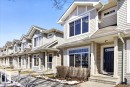 Row of townhomes featuring light-colored siding and dark entry doors - 18 6032 38 Avenue, Edmonton, AB  - Outdoor With Deck Patio Veranda With Facade 