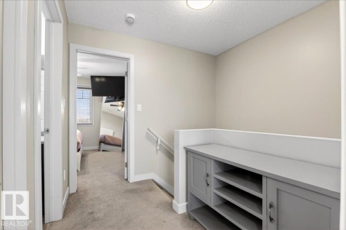 Hallway featuring built-in gray cabinetry with open shelving and closed storage - 18 6032 38 Avenue, Edmonton, AB - Indoor Photo Showing Other Room