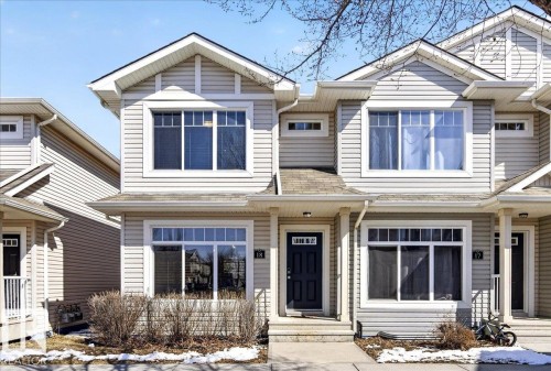 Light-toned siding exterior featuring multiple gables and a dark entry door with decorative glass - 18 6032 38 Avenue, Edmonton, AB - Outdoor With Facade