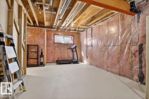 Unfinished basement area featuring exposed ceiling joists, visible HVAC ductwork, and insulation-lined walls with vapor barrier - 18 6032 38 Avenue, Edmonton, AB - Indoor Photo Showing Basement