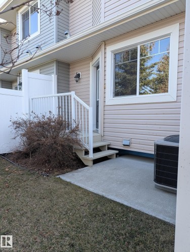 Exterior featuring a concrete patio, white vinyl siding, a multi-pane window, and a white privacy fence - 18 6032 38 Avenue, Edmonton, AB - Outdoor