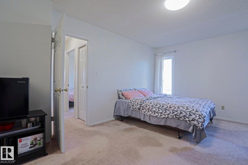 Carpeted room with white painted walls, a single window with white drapes, and a flush mount ceiling light fixture - 2433 89 Street, Edmonton, AB - Indoor Photo Showing Bedroom