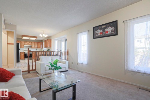 Open-concept living area featuring light-toned walls and neutral carpeting - 2433 89 Street, Edmonton, AB - Indoor Photo Showing Living Room