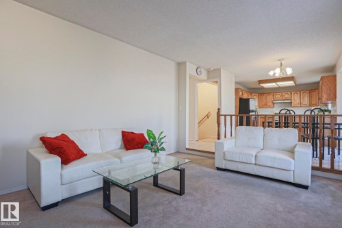 Open-concept living area featuring light-colored walls and plush carpet flooring - 2433 89 Street, Edmonton, AB - Indoor Photo Showing Living Room