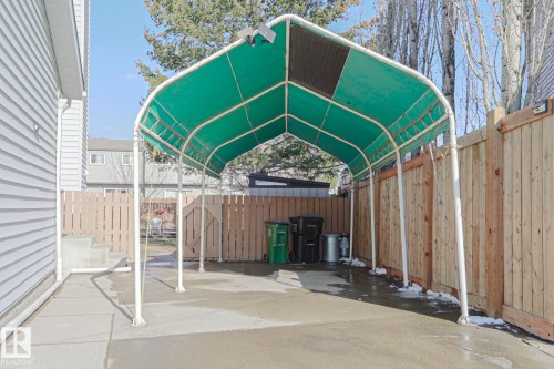 Covered carport structure featuring a green fabric canopy and white metal frame - 2433 89 Street, Edmonton, AB - Outdoor With Exterior