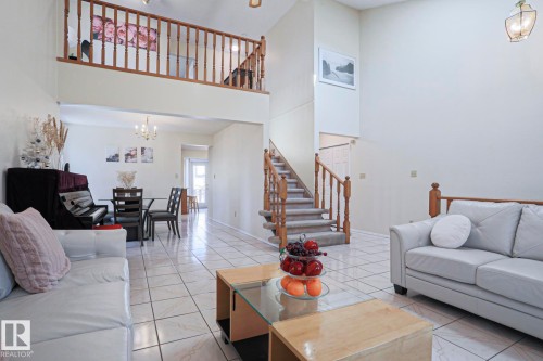 Open-concept living space featuring high ceilings and light-toned tile flooring - 2433 89 Street, Edmonton, AB - Indoor Photo Showing Living Room