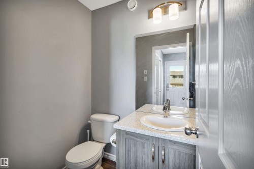 Bathroom featuring a modern vanity with a white oval sink, speckled countertop, and brushed nickel faucet - 2424 Wonnacott Crest, Edmonton, AB - Indoor Photo Showing Bathroom