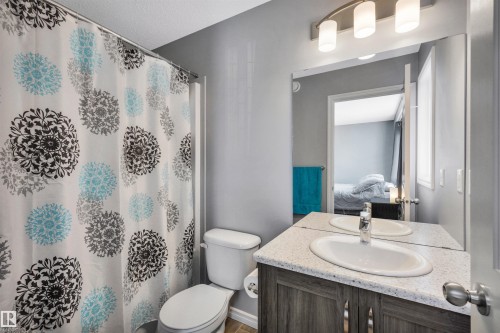 Bathroom featuring a vanity with a light-colored countertop, an undermount sink, and a chrome faucet - 2424 Wonnacott Crest, Edmonton, AB - Indoor Photo Showing Bathroom