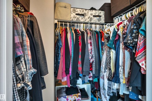 Walk-in closet featuring built-in wire shelving, multiple hanging rods, and integrated storage cubbies - 2424 Wonnacott Crest, Edmonton, AB - Indoor With Storage