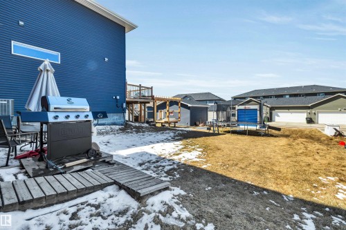 Expansive backyard featuring a partial wooden deck, a second-story wooden deck, and a detached shed - 2424 Wonnacott Crest, Edmonton, AB - Outdoor