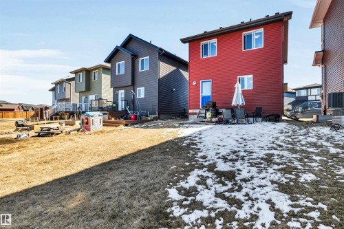 Expansive backyard featuring a large grass area, a partial wooden deck, and a raised garden bed - 2424 Wonnacott Crest, Edmonton, AB - Outdoor
