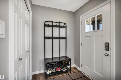 Entryway featuring a white paneled door with glass inserts, wood-finish flooring, and light gray walls - 2424 Wonnacott Crest, Edmonton, AB - Indoor Photo Showing Other Room