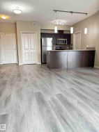 Open-concept living space featuring wood-finish flooring throughout - 
