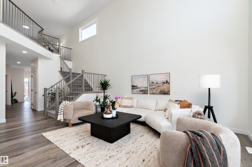 Open-concept living space featuring high ceilings and wood-finish flooring - 591 Boulder Wynd, Leduc, AB - Indoor Photo Showing Living Room