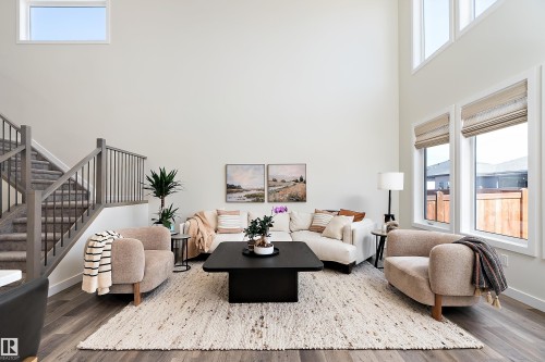 Expansive living area featuring soaring ceilings and abundant natural light from large windows - 591 Boulder Wynd, Leduc, AB - Indoor Photo Showing Living Room