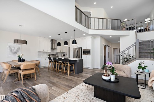 Open-concept living space featuring high ceilings and wood-finish flooring - 591 Boulder Wynd, Leduc, AB - Indoor