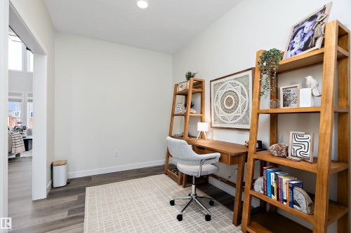 Bright interior space featuring wood-finish flooring and a vaulted ceiling - 591 Boulder Wynd, Leduc, AB - Indoor Photo Showing Office