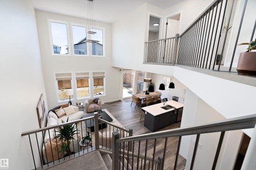 Two-story living area featuring a vaulted ceiling and a contemporary chandelier - 591 Boulder Wynd, Leduc, AB - Indoor Photo Showing Other Room