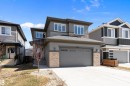 Contemporary exterior featuring multi-toned siding, stone accents, and a dual-panel garage door - 591 Boulder Wynd, Leduc, AB  - Outdoor With Facade 