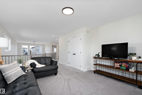 Carpeted loft area featuring a flush-mount ceiling light, white walls, and a white trim - 591 Boulder Wynd, Leduc, AB - Indoor Photo Showing Living Room