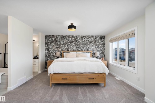 Spacious room featuring broadloom carpeting and a striking accent wall - 591 Boulder Wynd, Leduc, AB - Indoor Photo Showing Bedroom