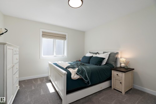 Bright bedroom featuring a large window with privacy blinds, neutral wall paint, and gray carpet flooring - 591 Boulder Wynd, Leduc, AB - Indoor Photo Showing Bedroom